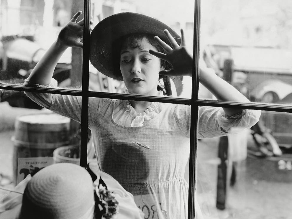一名對店內女帽感興趣的維多利亞時期婦女。