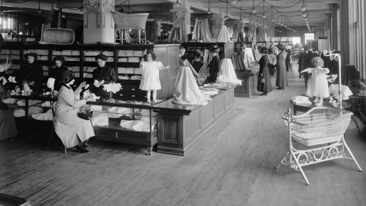 19世紀女性店員穿著得體的服飾，梳著整齊的髮髻來服務客人。